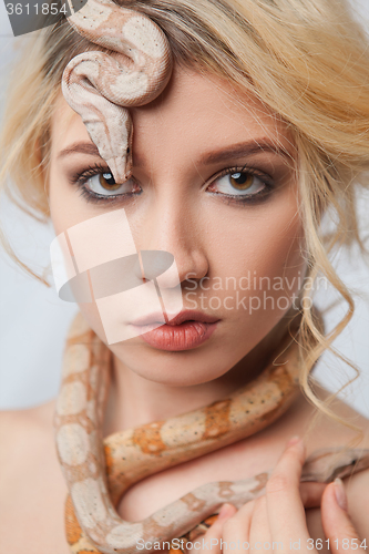 Image of Beautiful girl and a python, which wraps around her body