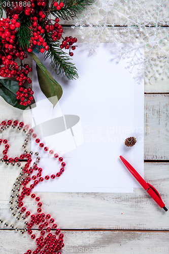 Image of The blank sheet of paper on the wooden table with a pen 