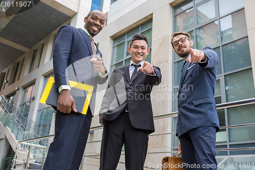 Image of Close-up of business team holding their thumbs up