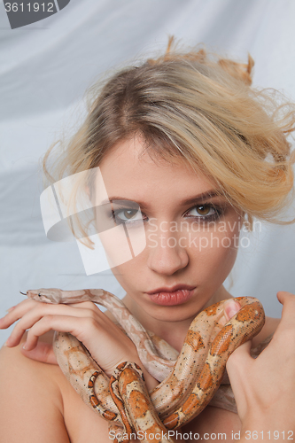 Image of Beautiful girl and the snake Boa constrictors, which wraps around her face