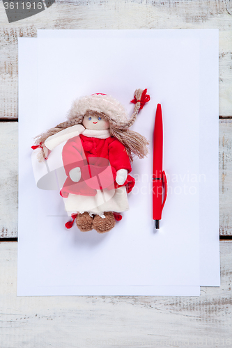 Image of The blank sheet of paper on the wooden table with a pen 