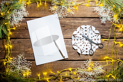 Image of The blank sheet of paper on the wooden table with a pen 