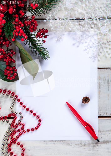 Image of The blank sheet of paper on the wooden table with a pen 