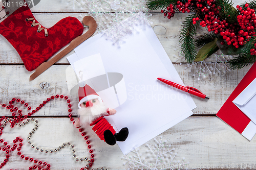 Image of The blank sheet of paper on the wooden table with a pen 