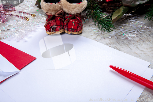 Image of The blank sheet of paper on the wooden table with a pen 