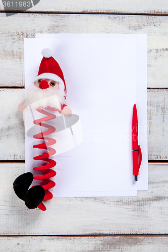 Image of The blank sheet of paper on the wooden table with a pen 