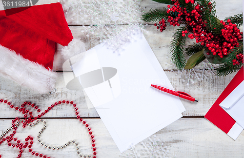 Image of The blank sheet of paper on the wooden table with a pen 