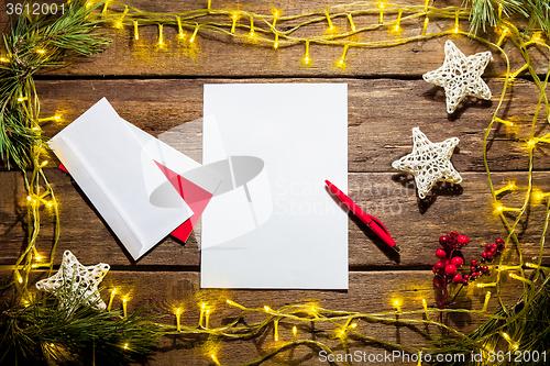 Image of The blank sheet of paper on the wooden table with a pen 