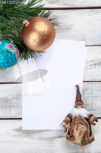 Image of The sheet of paper on wooden table with Christmas decorations 