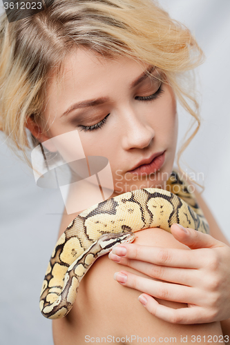 Image of Beautiful girl  holding a python, which wraps around her body