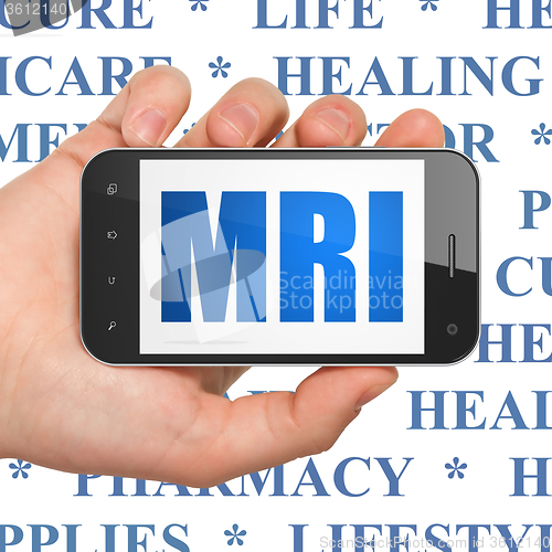Image of Healthcare concept: Hand Holding Smartphone with MRI on display