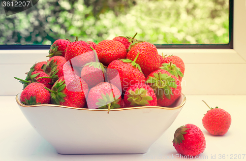 Image of Ripe strawberries in a ceramic vase.