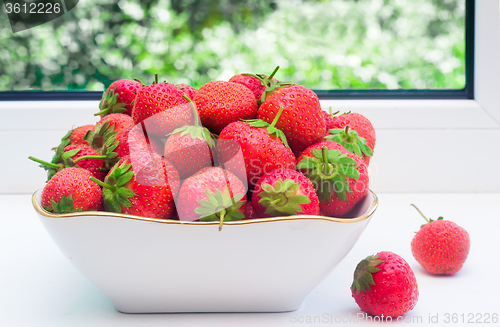 Image of Ripe strawberries in a ceramic vase.
