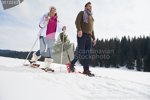 Image of couple having fun and walking in snow shoes