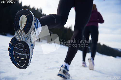 Image of couple jogging outside on snow