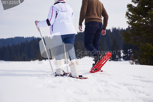 Image of couple having fun and walking in snow shoes