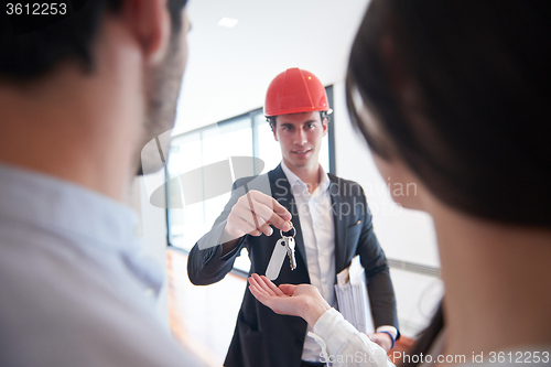 Image of couple buying new home with real estate agent