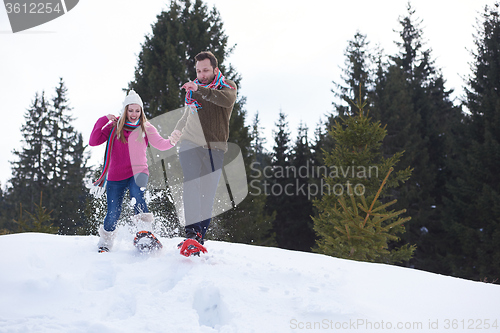 Image of couple having fun and walking in snow shoes