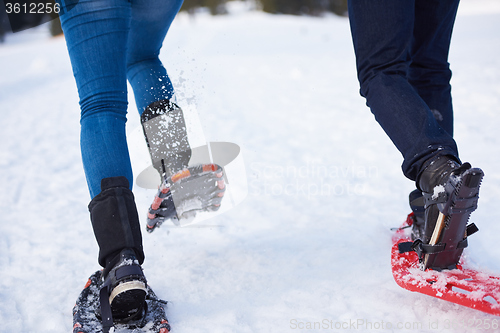 Image of couple having fun and walking in snow shoes