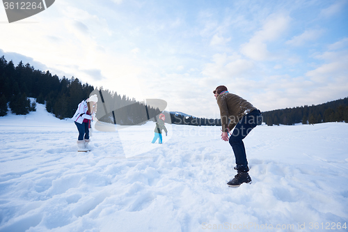 Image of happy family playing together in snow at winter