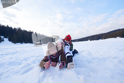 Image of romantic couple have fun in fresh snow and taking selfie