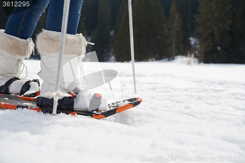 Image of couple having fun and walking in snow shoes