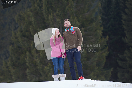 Image of couple having fun and walking in snow shoes