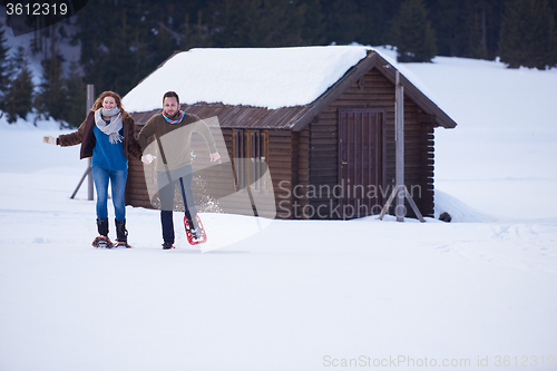 Image of couple having fun and walking in snow shoes