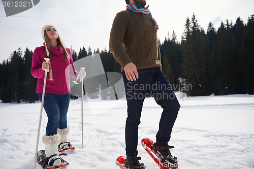 Image of couple having fun and walking in snow shoes