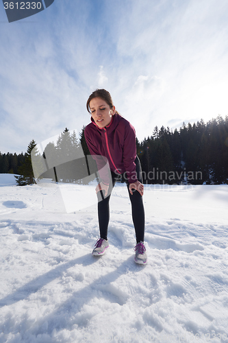 Image of yougn woman jogging outdoor on snow in forest