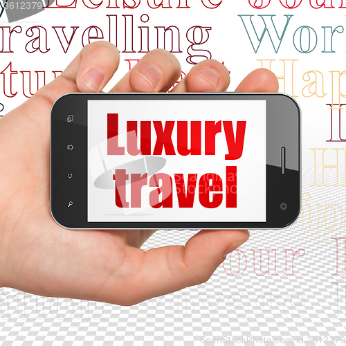 Image of Vacation concept: Hand Holding Smartphone with Luxury Travel on display
