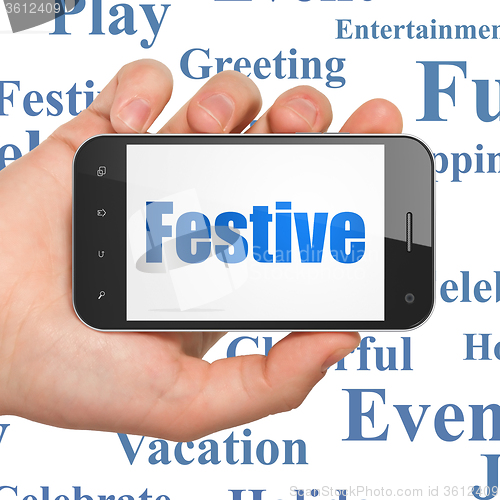 Image of Entertainment, concept: Hand Holding Smartphone with Festive on display