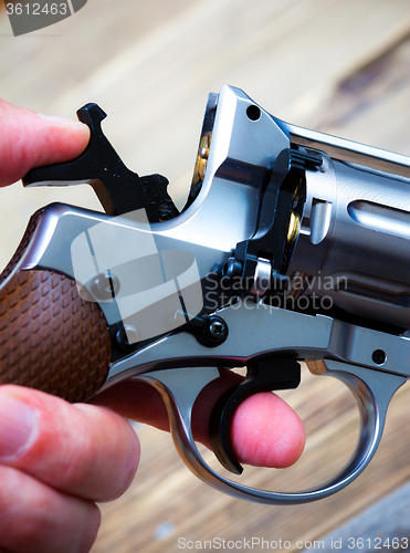 Image of revolver with the hammer cocked in his hand