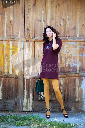 Image of woman in a burgundy dress with a handbag