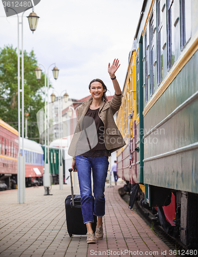 Image of smiling pretty middle-aged woman goes in a retro trip