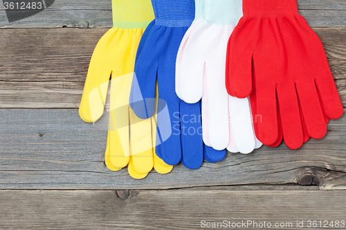 Image of four gloves on old wood boards