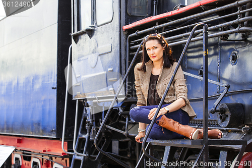 Image of beautiful woman near an old steam locomotive