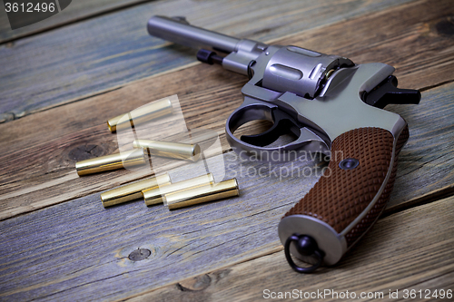 Image of silvery Nagan revolver with cartridges