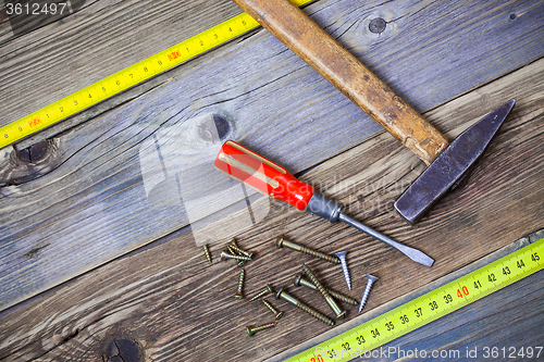 Image of Vintage hammer, screwdriver, screws and measuring tape