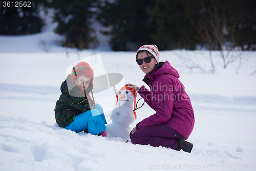 Image of happy family building snowman