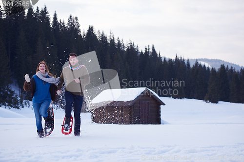 Image of couple having fun and walking in snow shoes