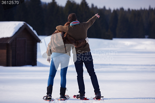 Image of couple having fun and walking in snow shoes