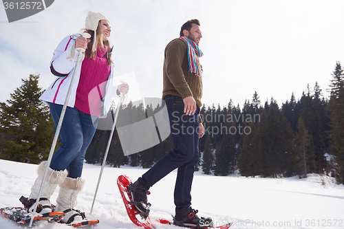 Image of couple having fun and walking in snow shoes