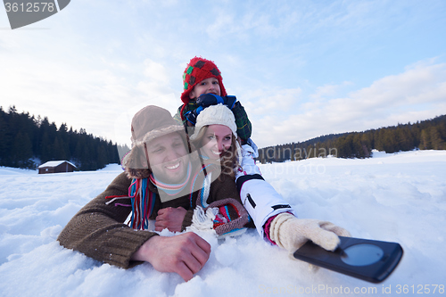 Image of romantic couple have fun in fresh snow and taking selfie