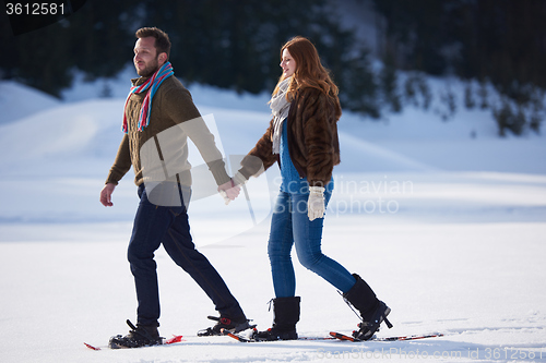 Image of couple having fun and walking in snow shoes