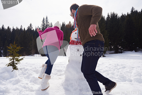 Image of happy family building snowman