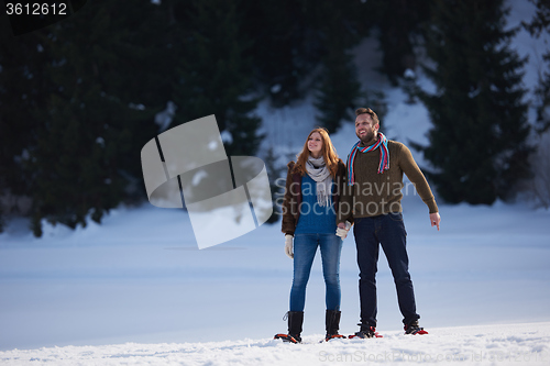 Image of couple having fun and walking in snow shoes