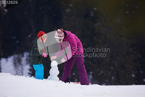 Image of happy family building snowman