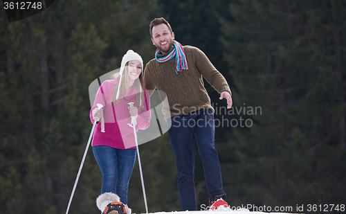 Image of couple having fun and walking in snow shoes