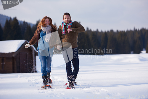 Image of couple having fun and walking in snow shoes